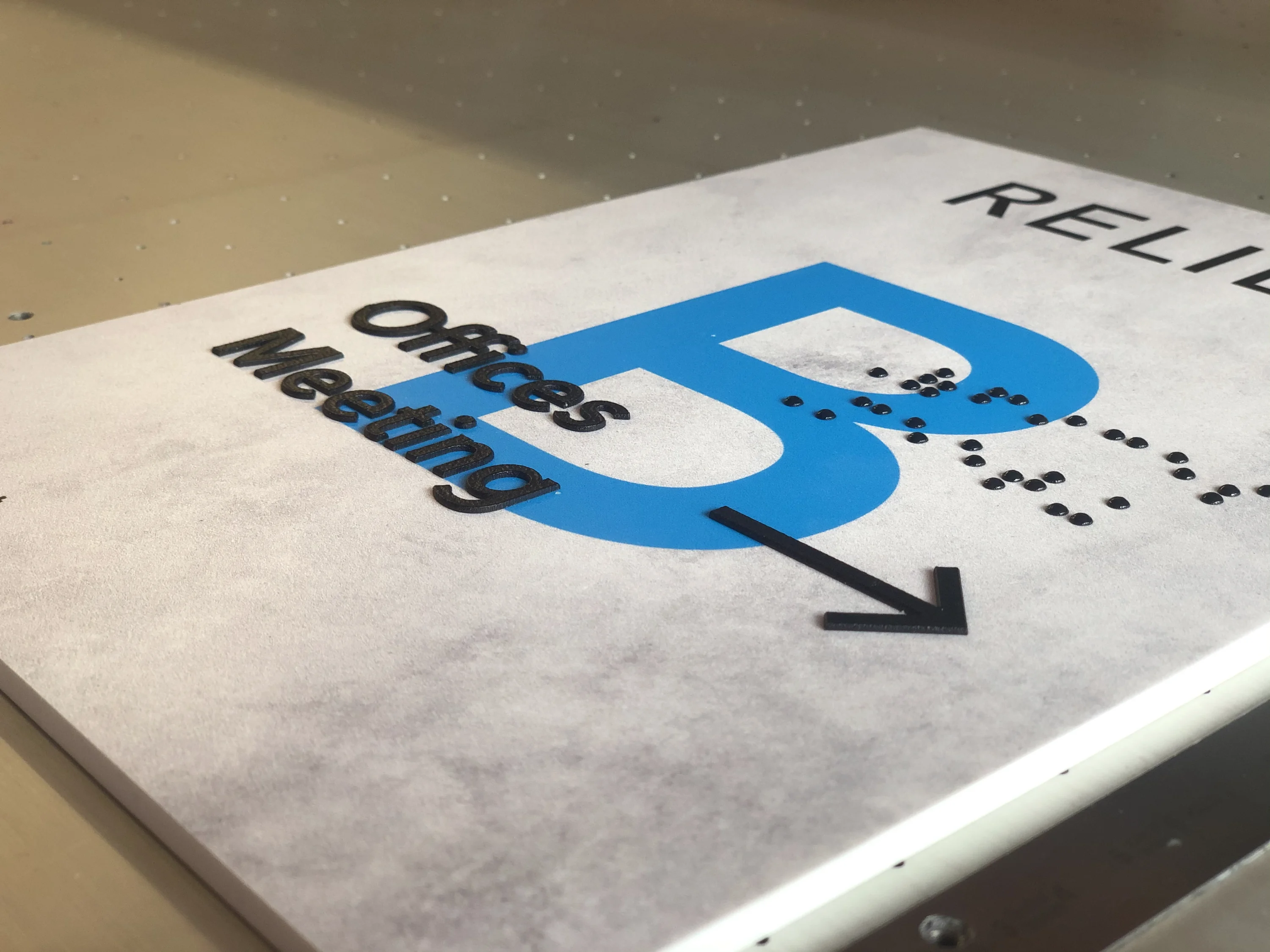 Raised lettering printed direct to board in a sign manufacturing workshop